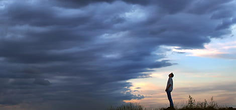 Man staring into gathering storm clouds